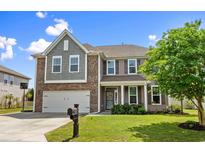 Charming two-story home featuring a manicured lawn, a two-car garage and a welcoming front porch at 3110 Bramble Glen Dr., Myrtle Beach, SC 29579