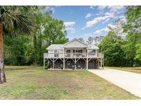 Inviting raised home featuring a charming wrap-around porch and a spacious driveway at 3798 Ed Smith Ave., Myrtle Beach, SC 29588