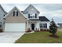 Charming two-story home featuring a brick and white facade, black shutters, and a well-manicured lawn at 4047 Bucolic Loop, Myrtle Beach, SC 29588