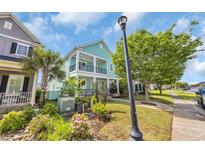 Charming two-story home featuring double porches, lush landscaping, and a classic street lamp at 868 Crystal Water Way, Myrtle Beach, SC 29579