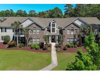 Attractive brick condo building with mature landscaping and a walkway to the entrance at 10 Logan Berry Ct. # H, Murrells Inlet, SC 29576
