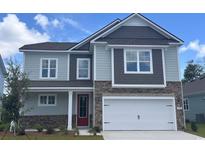 Charming two-story home with stone accents, a red front door, and a two-car garage at 1820 Hardwood Ct., Conway, SC 29526
