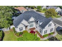 Well-maintained home with lush landscaping, white siding, black shutters, and a dark grey roof at 3300 Prioloe Dr., Myrtle Beach, SC 29588