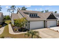 Charming two-story home with two car garage, concrete driveway, landscaped yard and palm trees at 351 Logan St., Little River, SC 29566