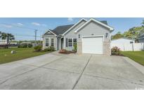 Charming home with gray siding, a spacious driveway, and attached garage at 107 Carolines Cove Ct., Myrtle Beach, SC 29588
