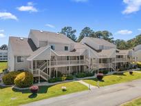Exterior view of townhomes featuring private entrances and manicured landscaping under a sunny sky at 1095 Plantation Dr. W # 29 N, Little River, SC 29566