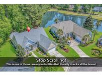 Stunning aerial view of a house with a pond and a well-maintained lawn at 1249 Trent Dr., Murrells Inlet, SC 29576