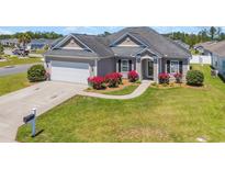 Charming single-story home with a manicured lawn, flower beds and an attached two-car garage at 1512 Virginia Pine Dr., Longs, SC 29568