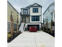 Two-story home boasting a modern design, prominent black trim, and a spacious concrete driveway at 168 West Palms Dr., Myrtle Beach, SC 29579
