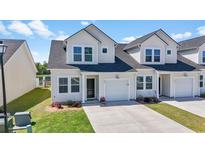 Charming townhome with white siding, inviting front yard, and private garage at 295 Brackish Dr. # 0673, Myrtle Beach, SC 29588