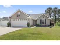 Charming one story home with a well manicured lawn and a two car garage at 305 Blue Rock Dr., Longs, SC 29568