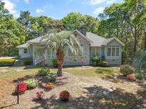 Charming single-story home featuring a brick facade, manicured landscaping, and mature trees at 321 Heather Ct., Sunset Beach, NC 28468