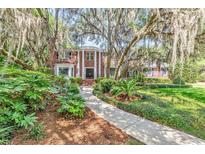 Charming brick home featuring a landscaped front yard with a walkway leading to the entrance, framed by mature trees at 356 Chapman Loop, Pawleys Island, SC 29585