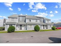 Attractive condo building featuring traditional architectural details and well-maintained landscaping at 3700 Golf Colony Lane # 18-G, Little River, SC 29566