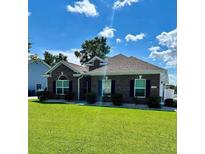 Charming brick home featuring a well-manicured lawn and tidy shrubbery in front at 388 Carriage Lake Dr., Little River, SC 29566