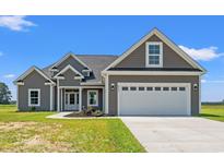Charming single-Gathering home featuring a gray exterior, attached garage, and landscaped front yard at 4022 Macks Rd, Aynor, SC 29511