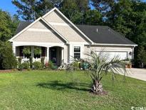 Charming single-story home with well-manicured lawn and lush landscaping, creating inviting curb appeal at 465 Tavistock Ct., Murrells Inlet, SC 29576