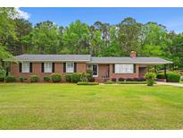 Charming brick ranch home featuring a well-maintained lawn and mature trees at 5033 Brantwood Dr., Mullins, SC 29574