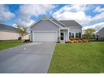 Charming single-story home featuring a well-manicured lawn, attached garage, and beautiful landscaping at 5039 Gladstone Dr, Conway, SC 29526