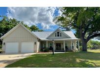 Charming home featuring a metal roof, a two-car garage, and a welcoming front porch perfect for relaxing at 521 Oak Lawn Rd., Georgetown, SC 29440