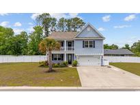Charming two-story home with a double porch, manicured lawn, and a white picket fence at 534 Pacific Commons Dr., Surfside Beach, SC 29575