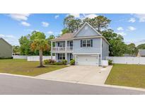 Charming two-story home featuring a double porch, attached garage, and well-maintained landscaping at 534 Pacific Commons Dr., Surfside Beach, SC 29575