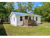 Charming home showcasing its inviting front porch and recently updated blue metal roof at 617 Sparrow Dr., Surfside Beach, SC 29575