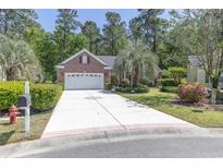 Charming brick home featuring a well-manicured lawn, a spacious driveway, and a two-car garage at 6486 Somersby Dr., Murrells Inlet, SC 29576