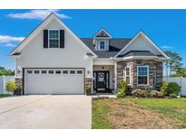Charming two-story home featuring a two-car garage, stone accents, and landscaped front yard with a welcoming entryway at 752 Hobonny Loop, Longs, SC 29568