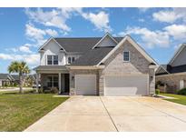 Stunning two-story home featuring a brick facade, attached two-car garage, and a well-manicured lawn at 801 Celene Ct., Myrtle Beach, SC 29579