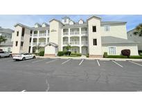 Three-story condo building featuring private balconies, white trim and lush landscaping at 1025 World Tour Blvd. # 205, Myrtle Beach, SC 29579