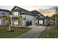 Striking two-story home featuring a stylish brick facade, complemented by lush landscaping and a private driveway at 1219 Bentcreek Ln., Myrtle Beach, SC 29579