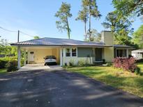 Charming single-story home with a metal roof, attached carport, and a well-maintained front lawn at 1506 7Th Ave., Conway, SC 29526