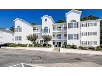 Stylish white condo building featuring multiple balconies, well-maintained landscaping, and a welcoming entrance at 1533 Lanterns Rest Rd. # 304, Myrtle Beach, SC 29579