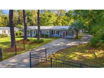 Charming single-story home with well-maintained lawn and mature trees at 3956 N Fraser St., Georgetown, SC 29440