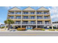 Three-story yellow condo building with multiple balconies and parking underneath, located near Grove Point at 4601 N Ocean Blvd. # 105, North Myrtle Beach, SC 29582