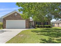 Charming brick home with a two-car garage and well-maintained lawn and garden at 561 Bucks Trail, Longs, SC 29568
