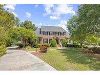 Inviting brick two-story home with a well-manicured lawn, mature trees, and a curved driveway leading to the residence at 8231 Forest Lake Dr., Conway, SC 29526