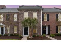 Charming brick townhome featuring a well-manicured lawn and a stylish black front door at 830 Howard Ave. # D, Myrtle Beach, SC 29577