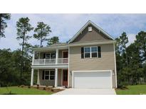 Two-story home featuring a two-car garage and a charming front porch on both levels at 880 Ireland Dr., Longs, SC 29568