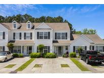 Charming townhome showcasing a white exterior, black shutters, and well-maintained landscaping at 1004 Harvester Ct. # 1004, Myrtle Beach, SC 29579