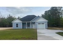 Charming single-story home with light blue siding and a well-manicured lawn and a driveway at 10522 W Highway 19, Loris, SC 29569