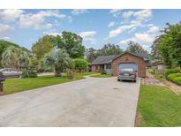 Charming brick home featuring an attached garage and long driveway at 112 Boxwood Ln., Conway, SC 29526