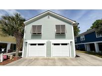 Two-story beach house with a two-car garage and a palm tree in the front yard at 1131 Camellia Dr., Surfside Beach, SC 29575