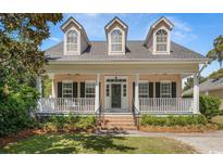 Charming home featuring a welcoming front porch, dormer windows, and a well-manicured lawn at 119 Berry Tree Dr., Pawleys Island, SC 29585