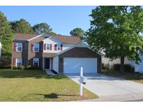Charming two-story home with brick and vinyl siding, red shutters, well-manicured lawn, and a two car garage at 148 Weeping Willow Dr., Myrtle Beach, SC 29579