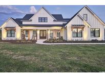 Stunning two-story white farmhouse with a dark roof and manicured lawn at 2300 Tansy Rd., Loris, SC 29569