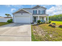 Charming two-story home with a well-maintained lawn and an attached two-car garage at 417 Spruce Pine Way, Conway, SC 29526