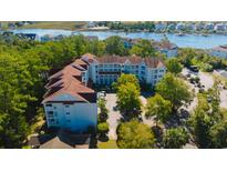 Stunning aerial view of the condo complex surrounded by lush greenery and waterfront views at 4601 Greenbriar Dr. # 201, Little River, SC 29566