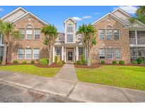 Inviting brick condo with a manicured lawn, mature trees, and an elegant entrance at 4648 Fringetree Dr. # C, Murrells Inlet, SC 29576